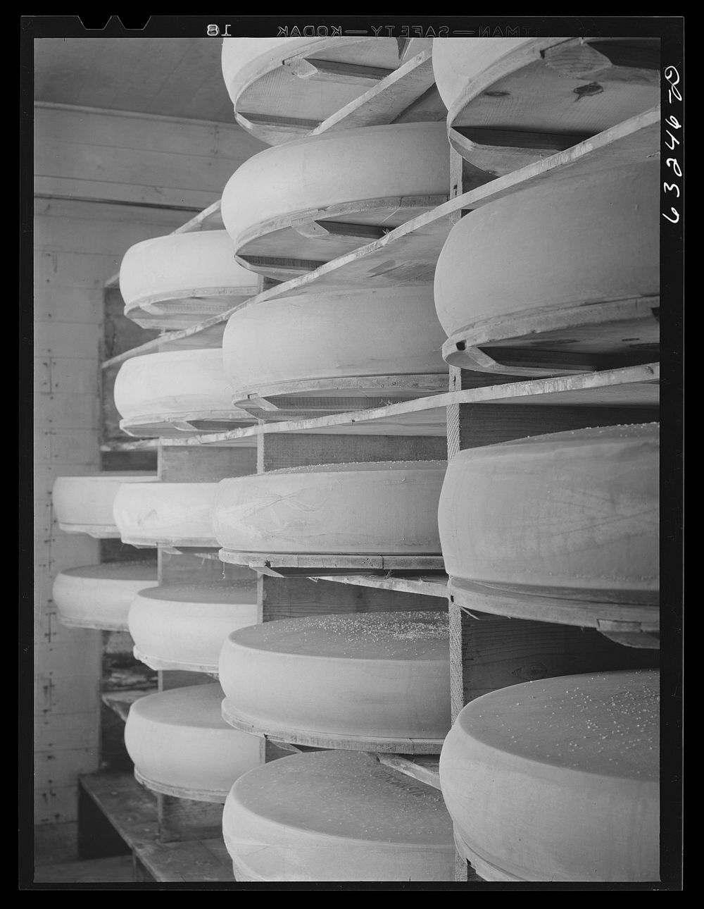 Cheese in storage. Swiss cheese factory. Madison, Wisconsin. Sourced from the Library of Congress.