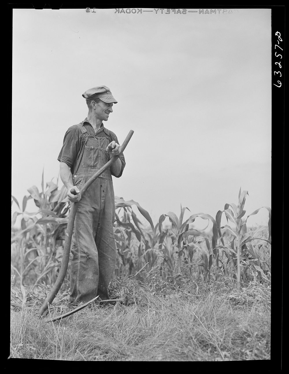 Farmer cutting weeds along edge of cornfield. Richland County, Wisconsin. Sourced from the Library of Congress.