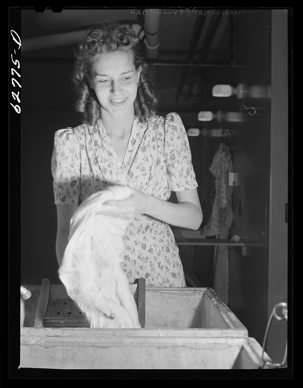 Wife of defense worker washing clothes in utility building at FSA (Farm Security Administration) trailer camp. Erie…