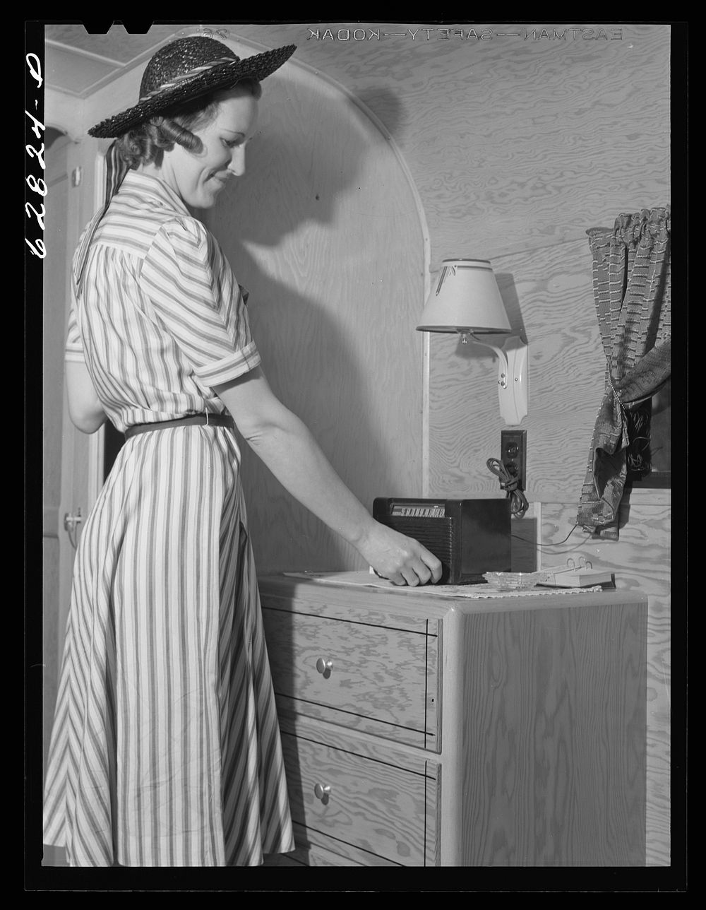 Tuning in radio in trailer at FSA (Farm Security Administration) camp. Erie, Pennsylvania. Sourced from the Library of…