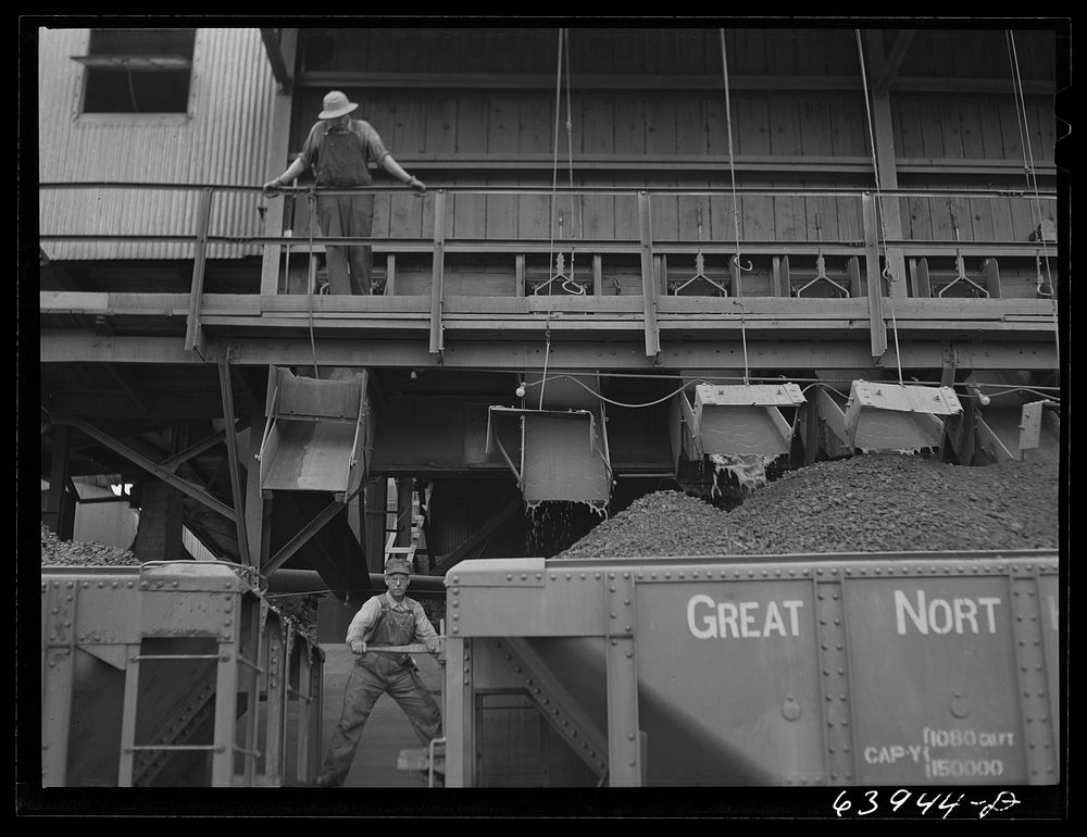 Washed ore being loaded into seventy ton cars for shipment to Duluth-Superior ore docks. Concentration plant at Bovey…