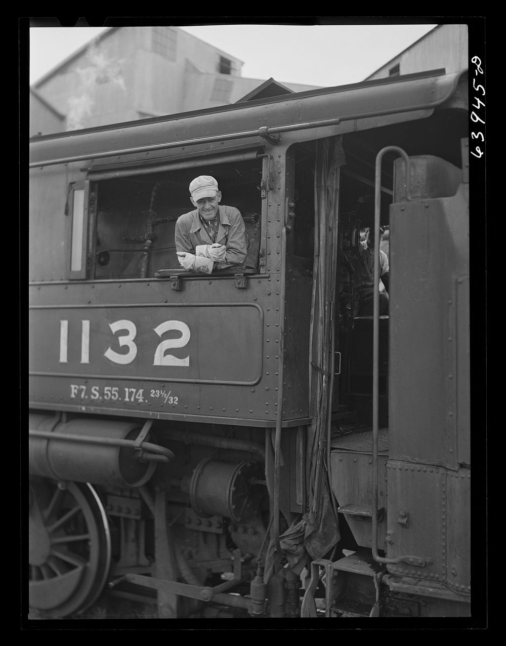 [Untitled photo, possibly related to: Railroad engineer who brings ore cars up from open pit mine to concentration plant…
