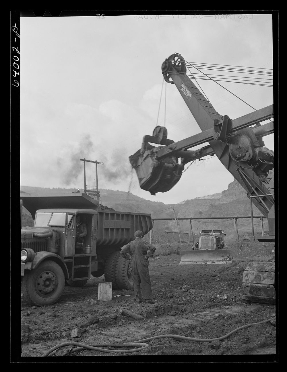 [Untitled photo, possibly related to: Loading trucks with iron ore at the Albany mine, Hibbing, Minnesota. This mine…