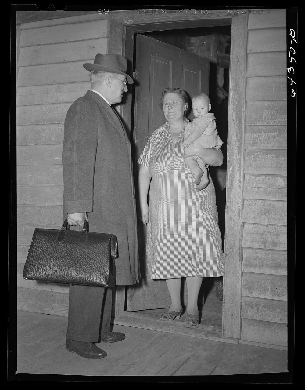 Scott County, Missouri. Country doctor giving parting advice to mother of sick child. Sourced from the Library of Congress.