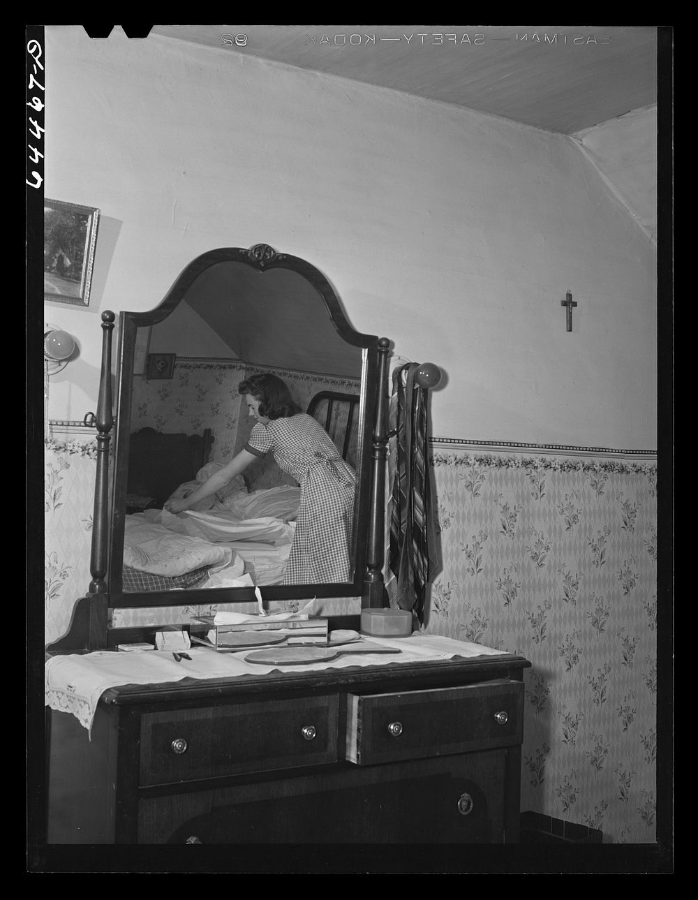 Meeker County, Minnesota. Elaine McCormick, one of the McRaith grandchildren, making the beds in the morning before school…