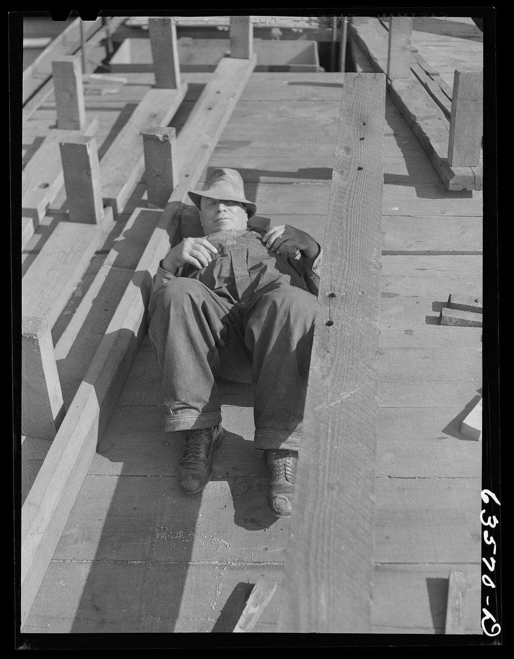 Crew member resting while Great Lakes boat "James Watt" is being loaded with wheat to go to Buffalo flour mills. Elevator…