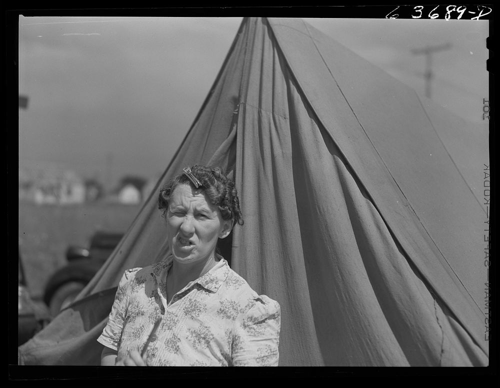 Mrs. Ash, wife of defense worker. They are living in a tent beside the foundation of their new home which they are building…