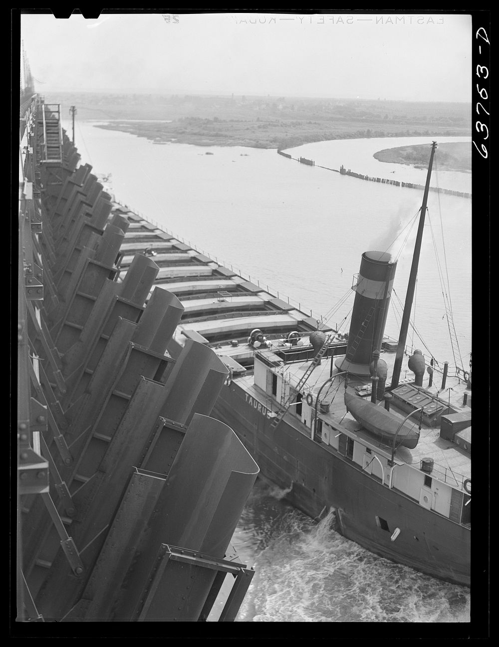 Lake boat has entered through port of Duluth and is pulling up at ore dock. Allouez, Wisconsin. Sourced from the Library of…