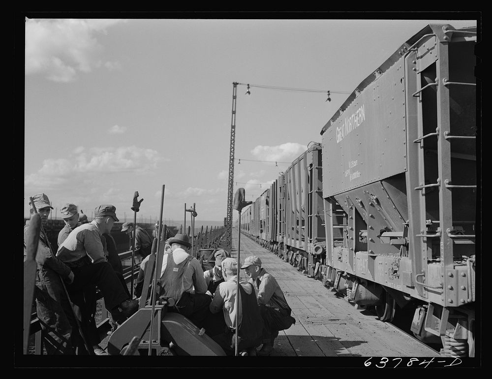 Ore punchers waiting for signal to begin unloading cars of ore into bins on dock. Allouez, Wisconsin. Sourced from the…