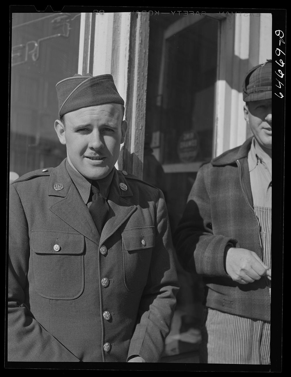 [Untitled photo, possibly related to: Bowdle, South Dakota. Soldier on furlough with friends in front of pool hall]. Sourced…