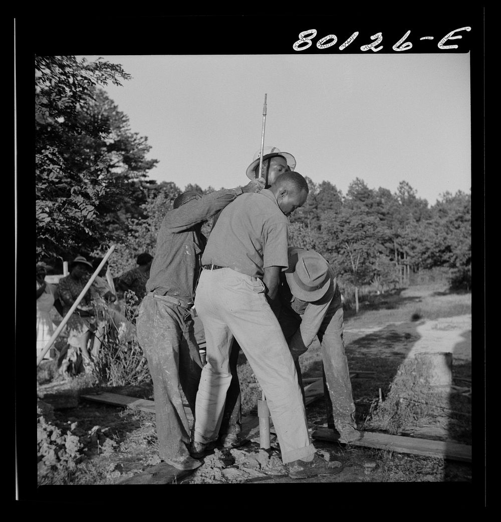 [Untitled photo, possibly related to: Mr. Slater, engineer, and well crew straining on pump rod, temporarily fouled in…