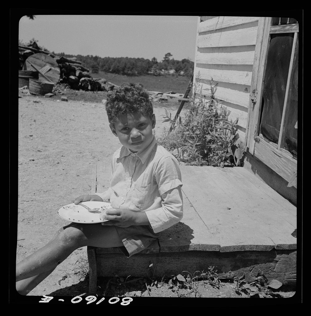 [Untitled photo, possibly related to: John Fredrick's son eating his lunch in the sun. Charles County, Maryland, near La…