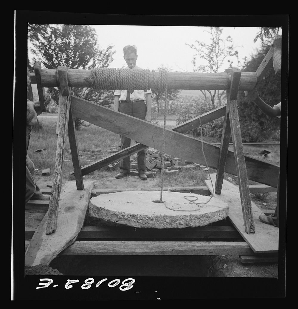 Cement cap hanging in windlass prior to lowering into well. John Hardesty well project, Charles County, Maryland. Sourced…