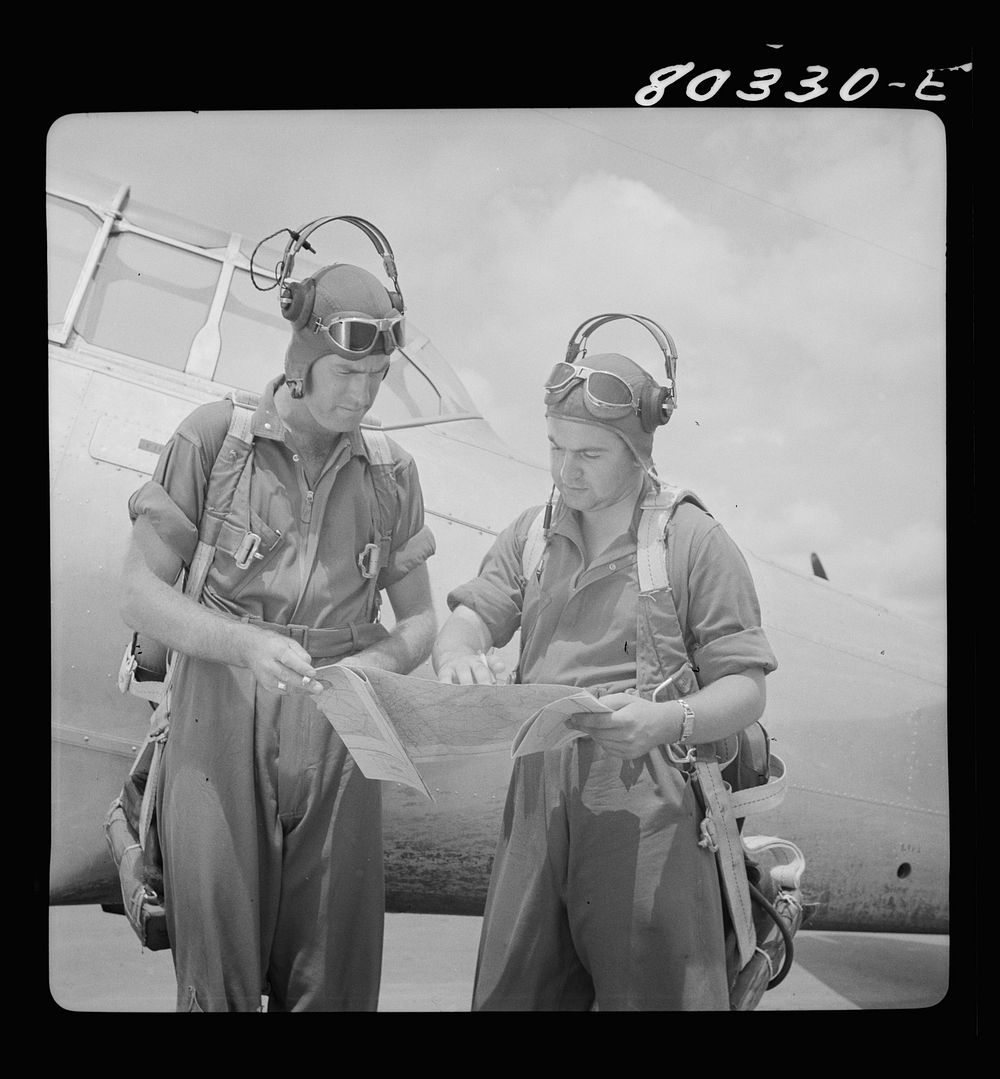 Flight instructors E.E. McTaggart and J.C. Gumison chart the day's flight. Craig Field, Southeastern Air Training Center…