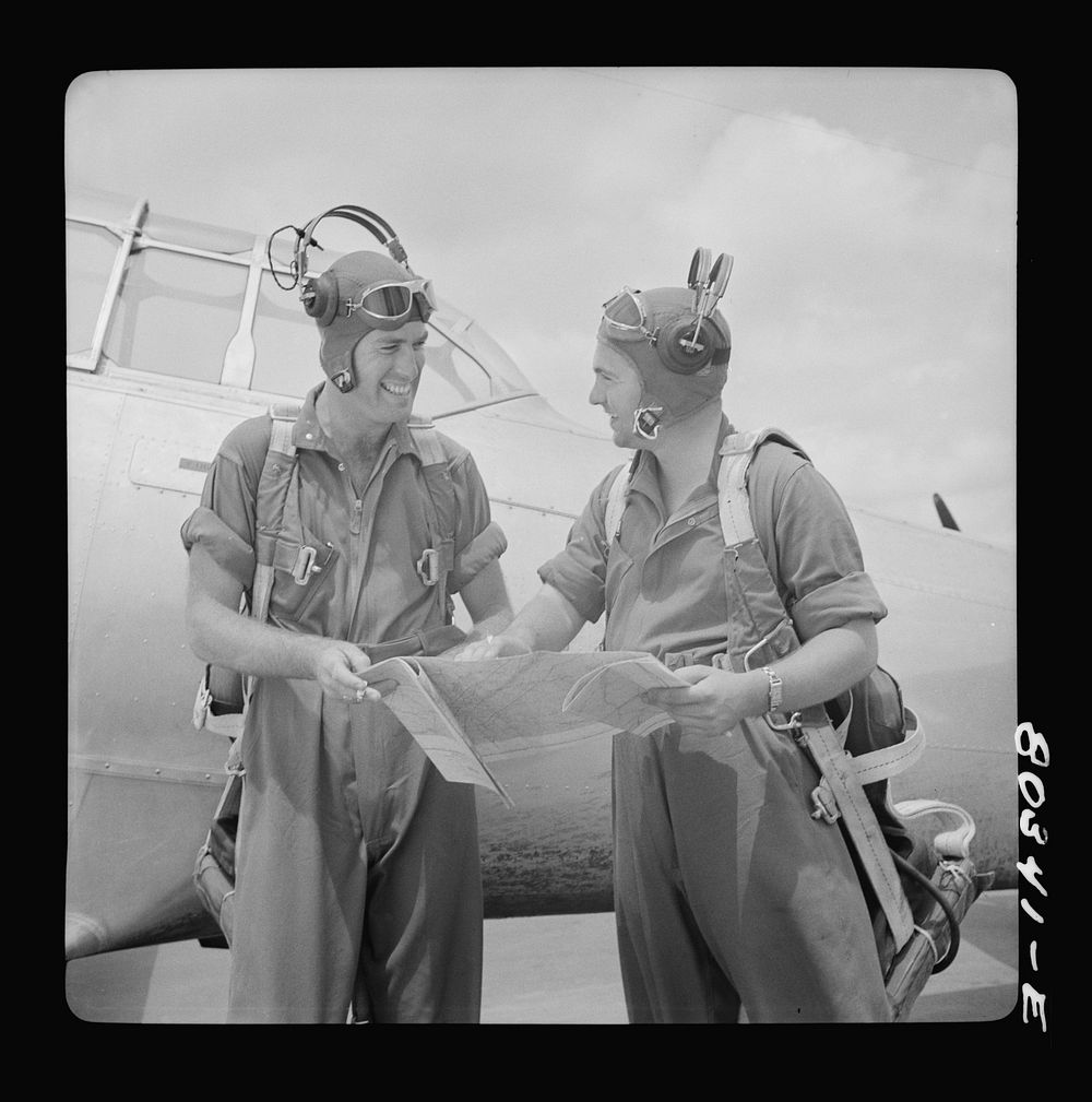 Flight instructors McTaggart and Gumison chart the afternoon flight after fried chicken dinner. Craig Field, Southeastern…