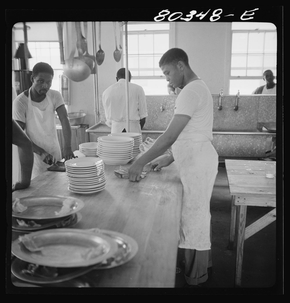Craig Field cooks setting out plates for chicken dinner. Craig Field, Southeastern Air Training Center, Alabama. Sourced…