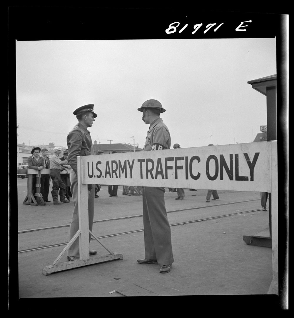 Army sentries standing guard at transport dock one day after the Japanese attack on Pearl Harbor. San Francisco, California.…