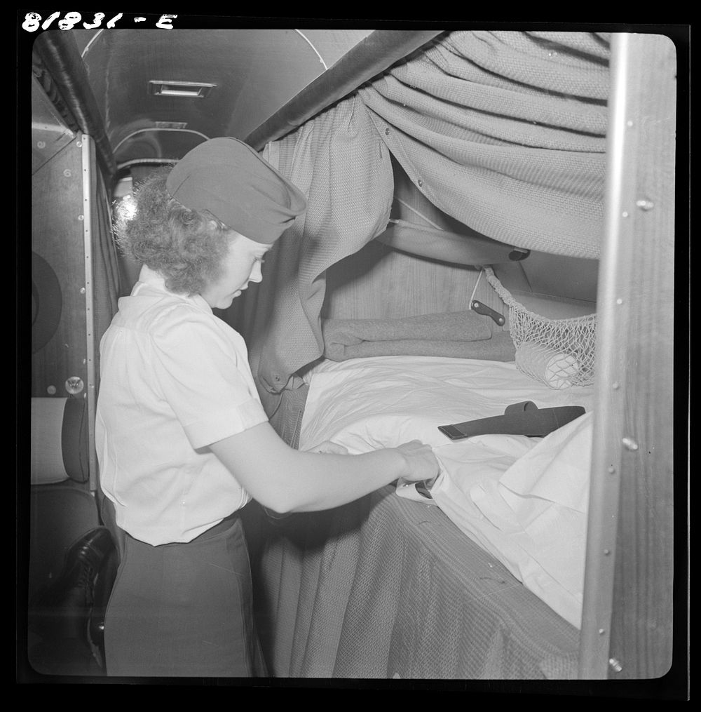 Stewardess aboard American airliner, making up an "upper" bunk. San Francisco, California. Sourced from the Library of…