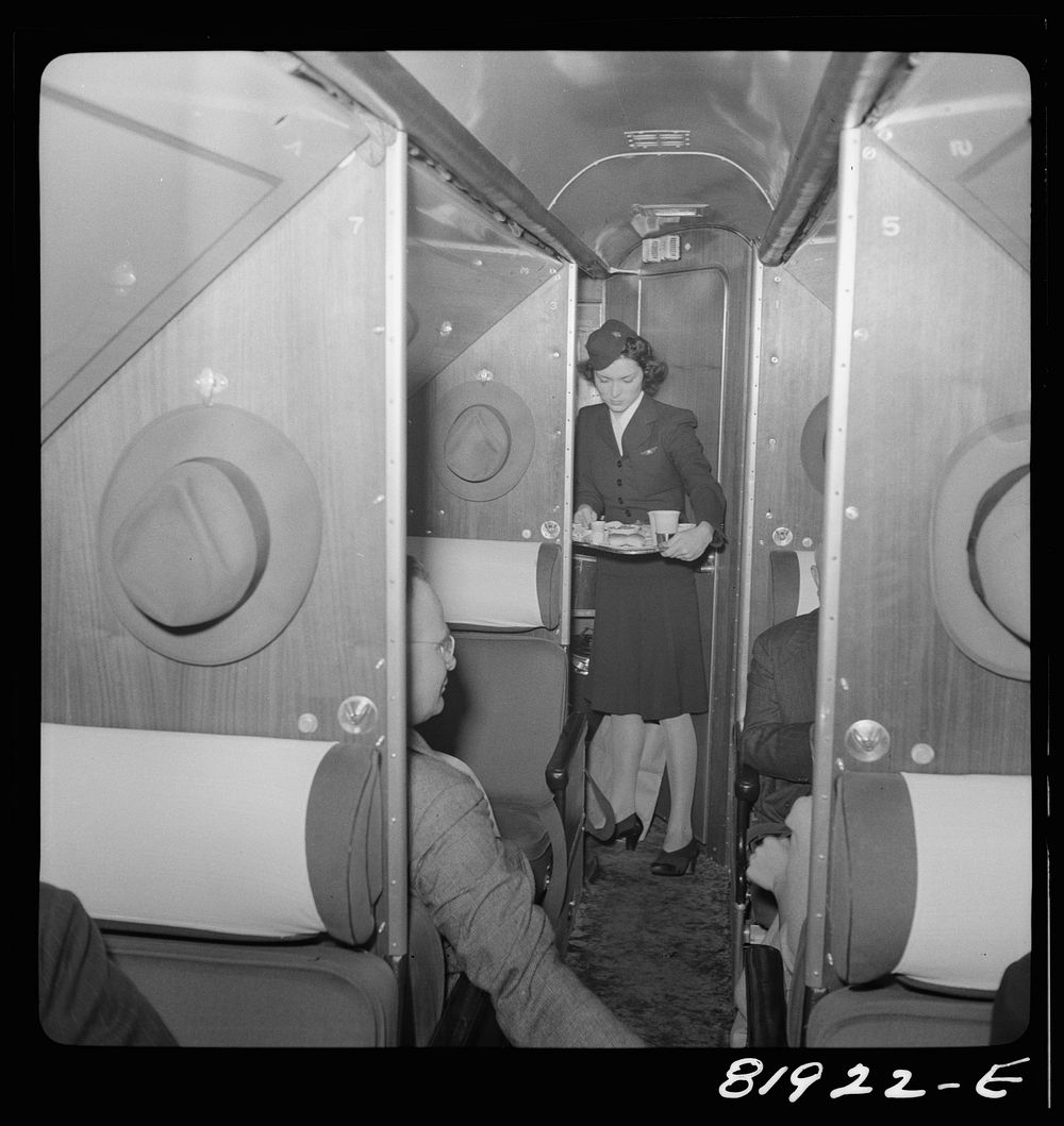 Stewardess serving dinner aboard an American airliner enroute from Washington to Los Angeles. Sourced from the Library of…