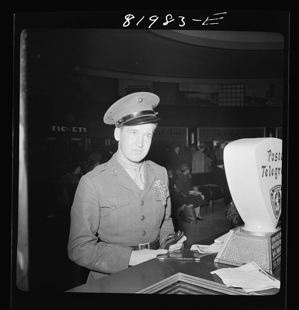 Washington, D.C.  United States Marine in Greyhound bus depot, just home from Cuba, thinking up a Christmas telegram to his…