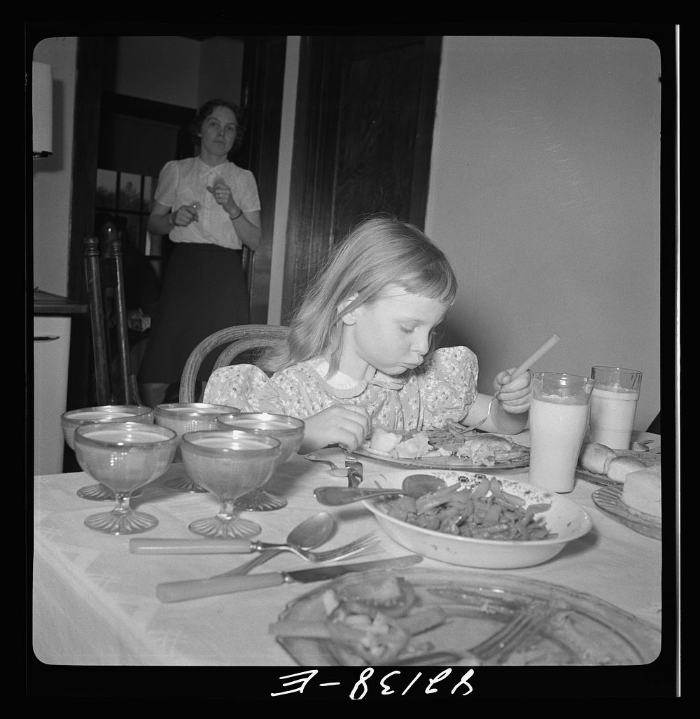 Little girl on a farm in Maryland, learning to eat vitamins. Sourced from the Library of Congress.