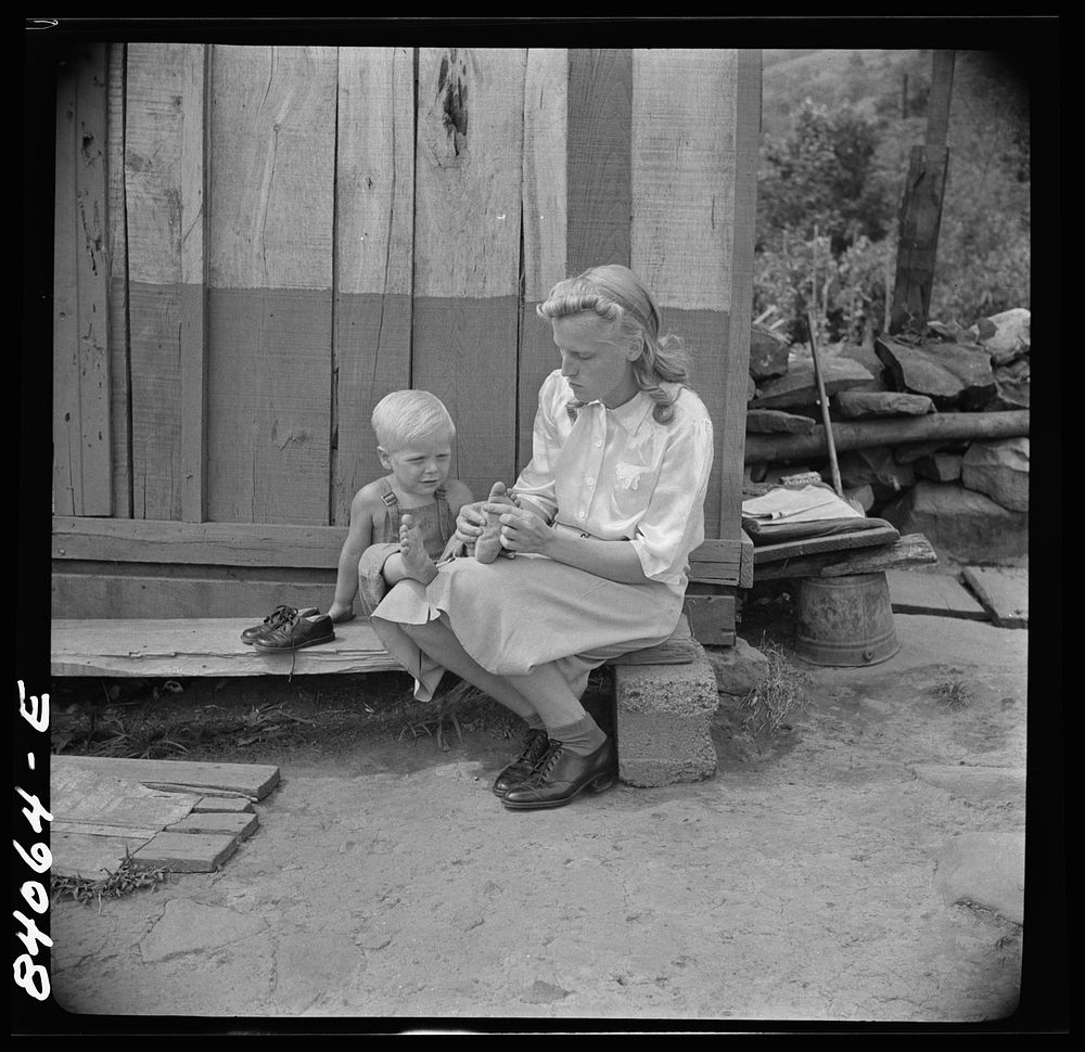 Richwood, West Virginia. (vicinity) Hazel Friend and her son, Darriell, in front of their home. Sourced from the Library of…
