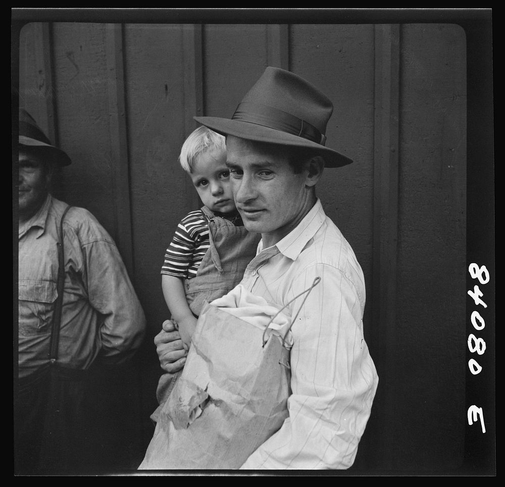 Richwood, West Virginia. Father and son boarding train for Batavia, New York, where they will work in the harvest. Sourced…