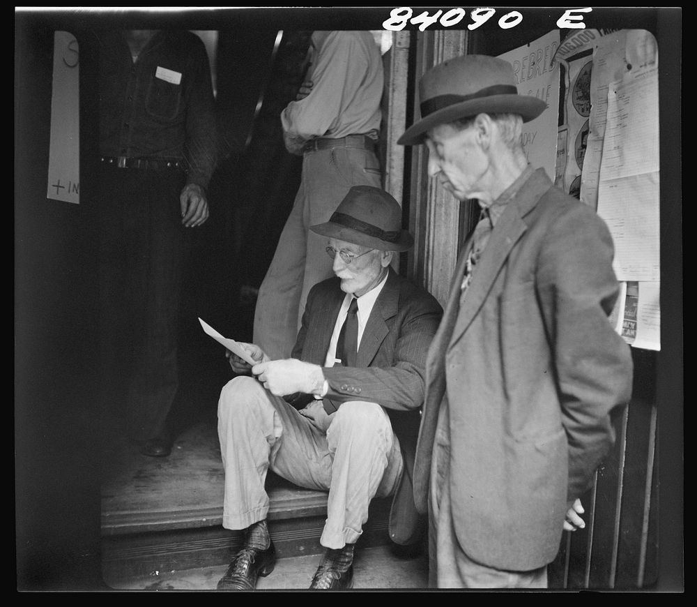 Summersville, West Virginia. Oldsters examining the FSA (Farm Security Administration) contract for migratory labor. Sourced…