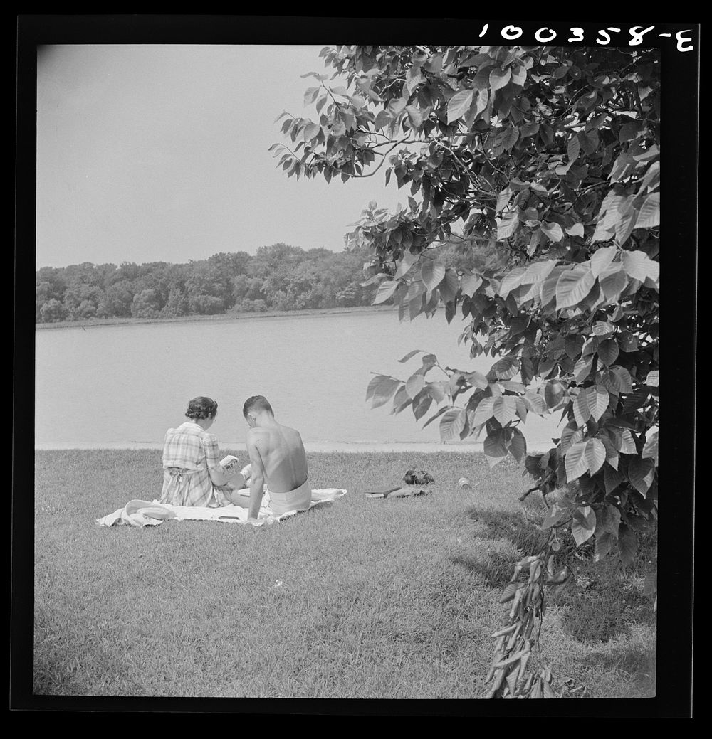 Washington, D.C. Reading beside the Potomac River in East Potomac park on Sunday. Sourced from the Library of Congress.