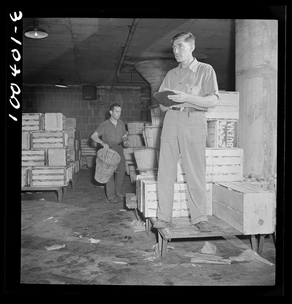 Washington, D.C. District grocery store warehouse on 4th Street S.W. Foreman calling out orders from the platform, which men…