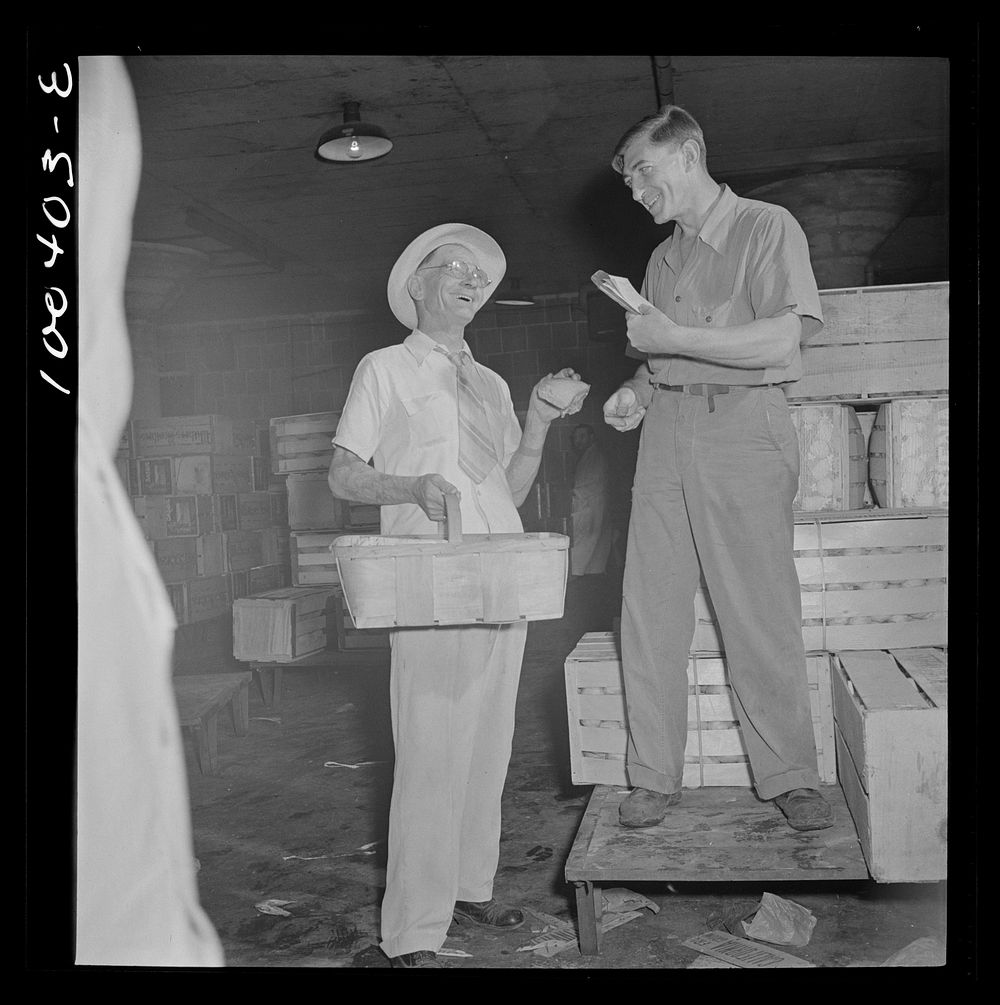 Washington, D.C. District grocery store warehouse on 4th street S.W. Store owner kidding with the order foreman. There are…