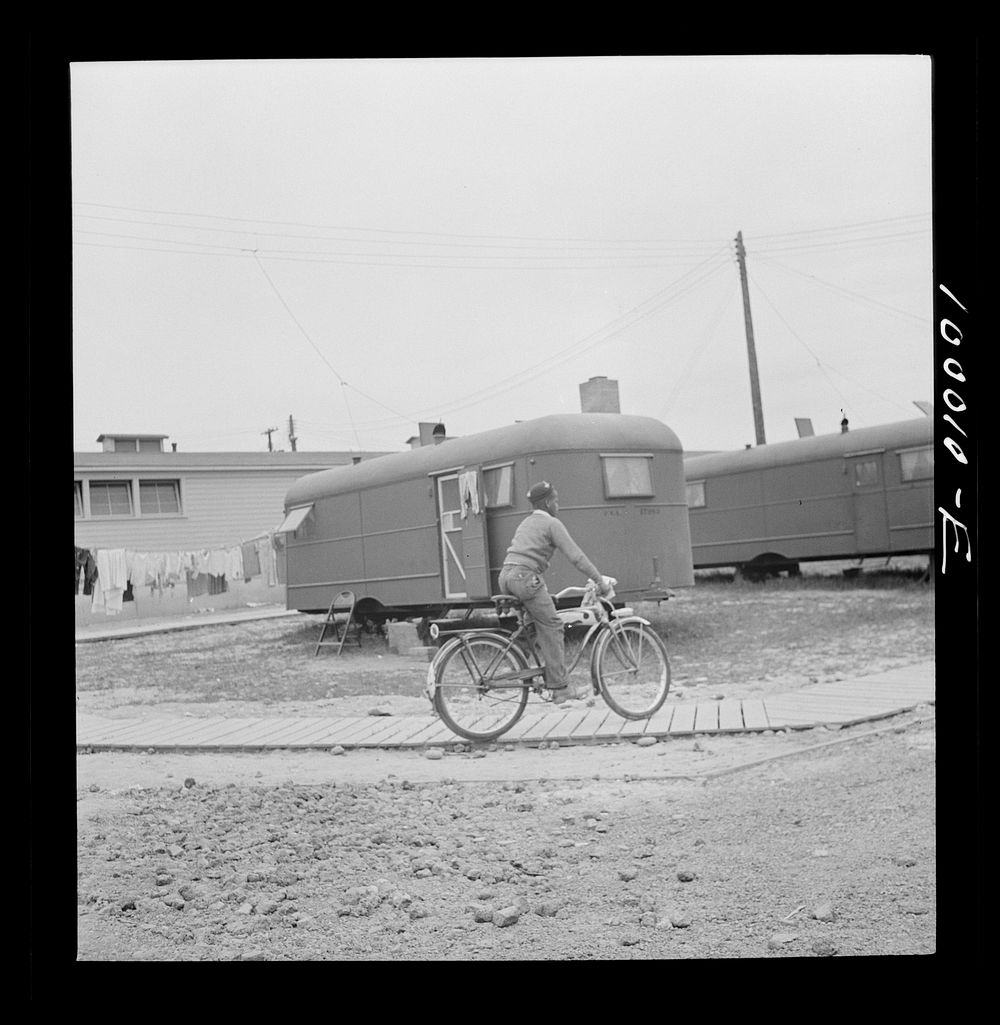 Arlington, Virginia. FSA (Farm Security Administration) trailer camp project for es. Young occupant gets around by bicycle.…
