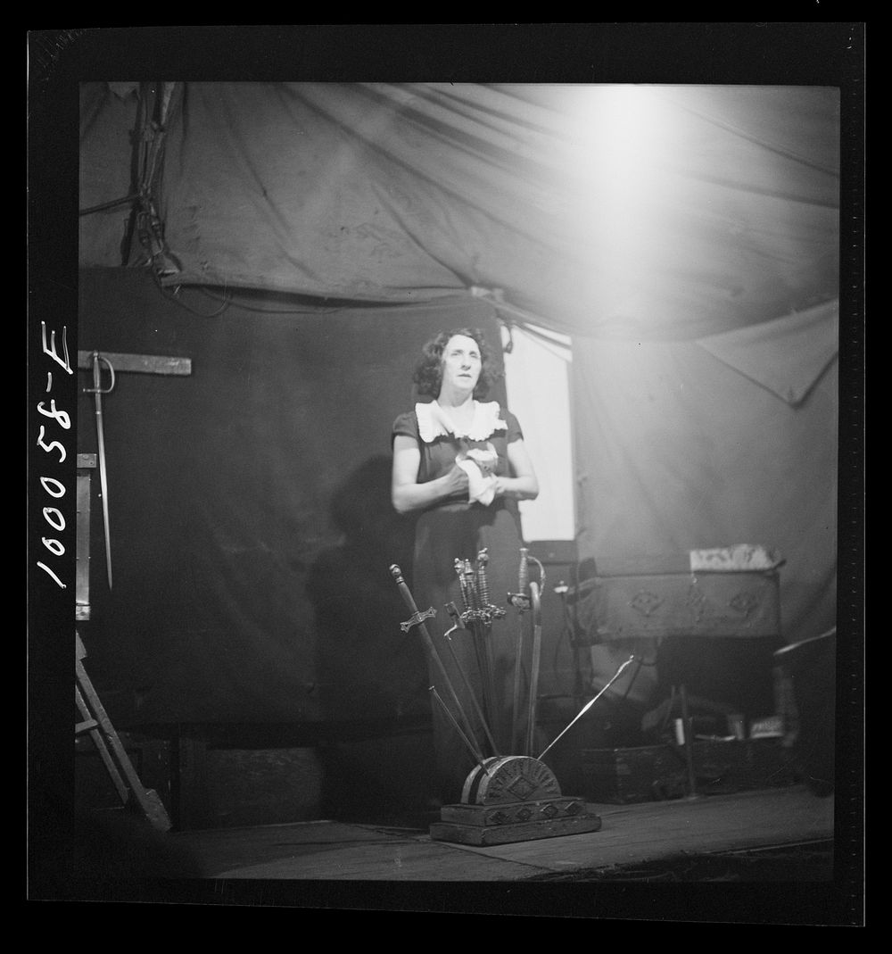 [Untitled photo, possibly related to: Norfolk, Virginia. Sword swallower in a travelling railroad show resting between…