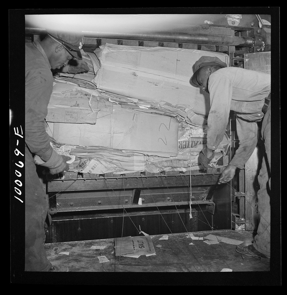 Washington, D.C. Salvage drive, Victory Program. Scrap paper, after being packed in hydraulic press, is baled with wire in…