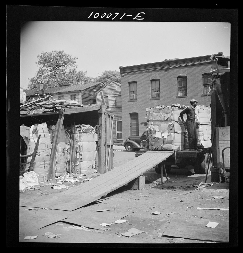 Washington, D.C. Salvage drive, Victory Program. Bales of scrap paper stored in yard of District retail junk company are…