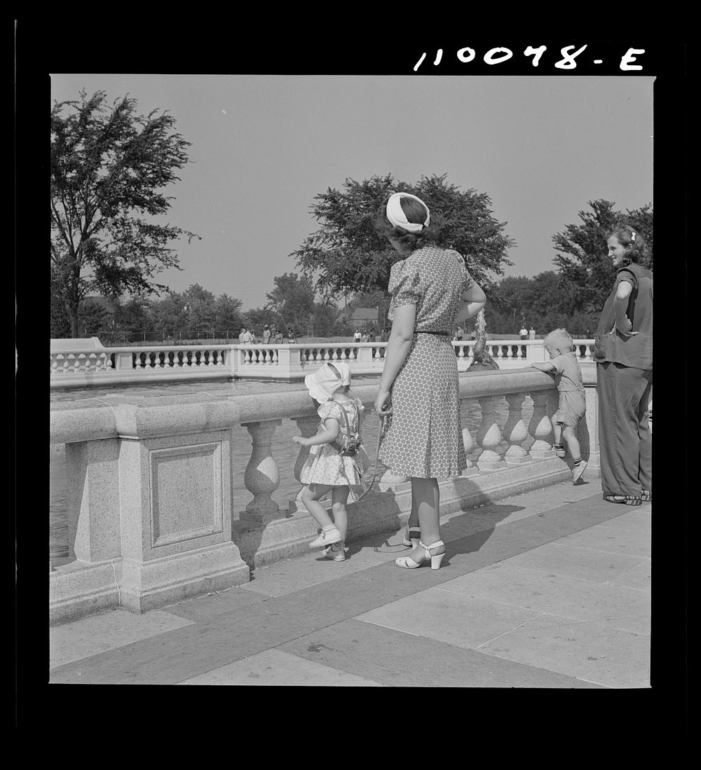 [Untitled photo, possibly related to: Detroit, Michigan. Woman adjusting a harness strap to prevent child from getting lost…