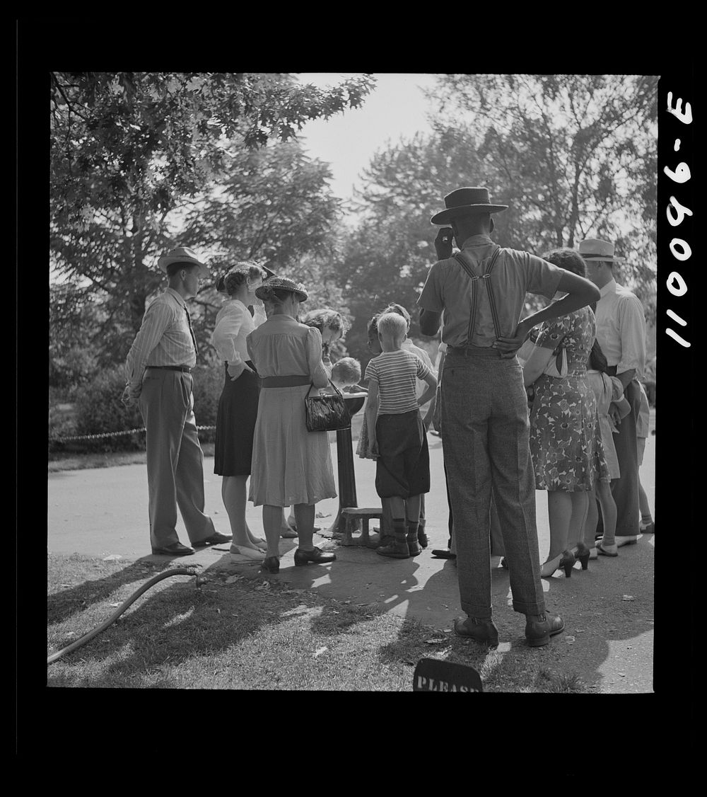 Detroit, Michigan. Group waiting to drink water out of a public fountain in the zoological park. Sourced from the Library of…