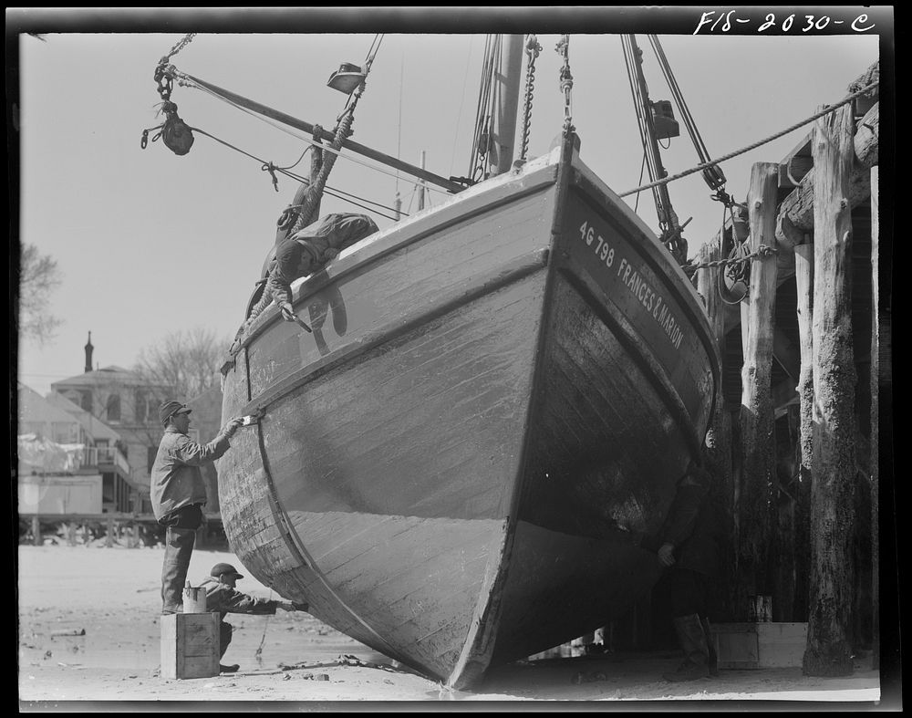 Provincetown, Massachusetts. The crew of the Frances and Marion, a Portuguese trawler, painting ship on the beach. Sourced…