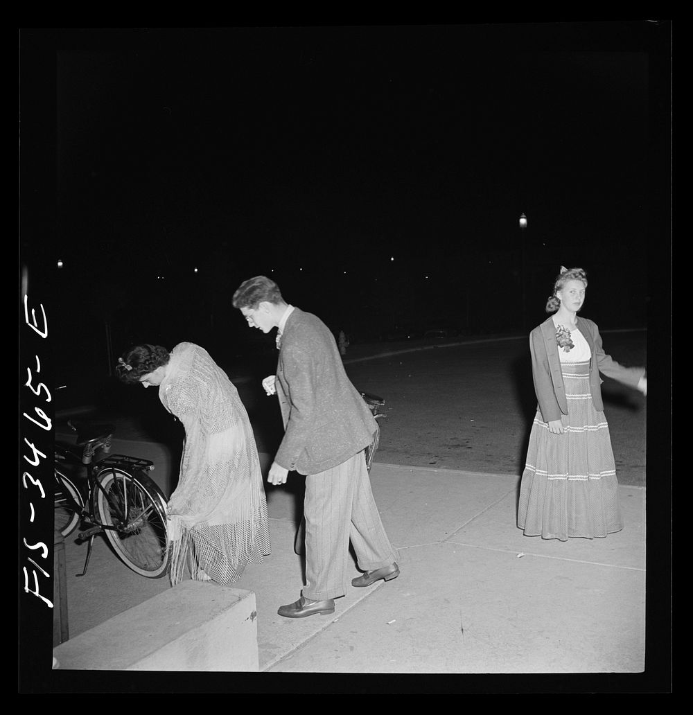 Greenbelt, Maryland. Federal housing project. Arrival at the senior prom catches her dress on a bicycle, Greenbelt's most…