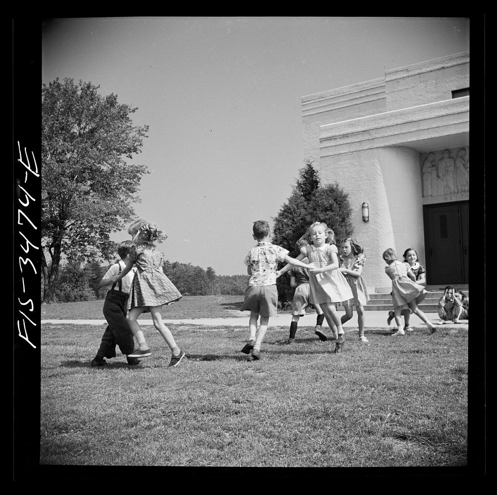 Greenbelt, Maryland. Federal housing project. Kindergarten children practice their May Day dances on the grass in front of…