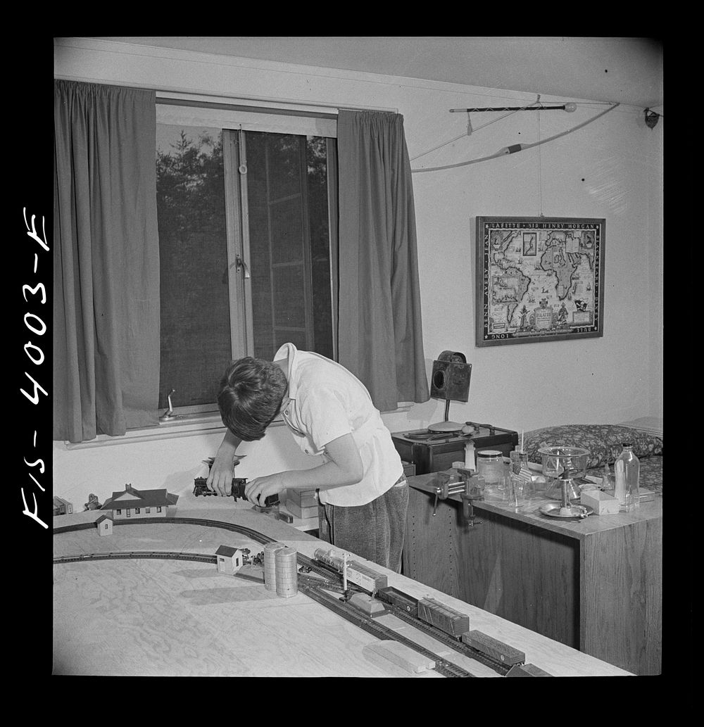 Greenbelt, Maryland. Child's bedroom in a house in which a thirteen year-old boy has rigged up model trains and a chemical…