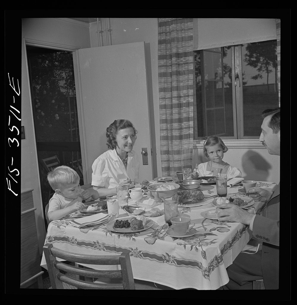 Greenbelt, Maryland. Federal housing project. Mr. and Mrs. Leslie Atkins, Ann, and Pierce Atkins having supper. Sourced from…