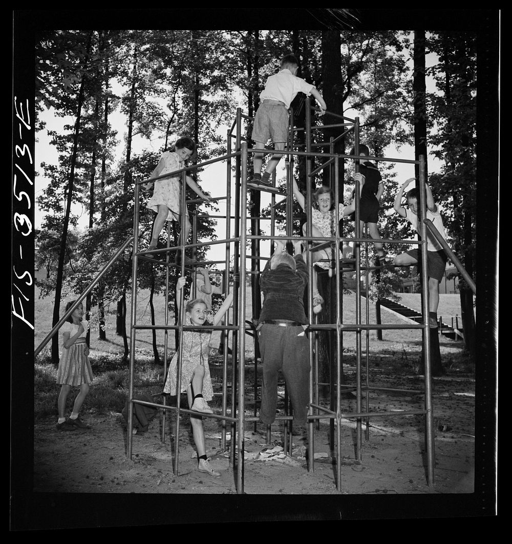 Greenbelt, Maryland. Federal housing project. Children playing on apparatus in one of the numerous playgrounds situated in…