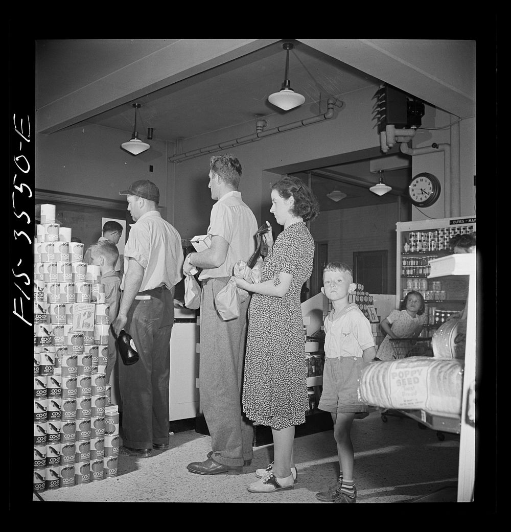 Greenbelt, Maryland. Federal housing project. Waiting to pay for purchases at checking gate in the cooperative grocery…