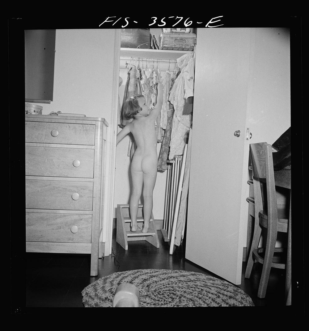 Greenbelt, Maryland. Ann Atkins taking a dress out of her closet by climbing on the ladder built especially for her. Ann is…