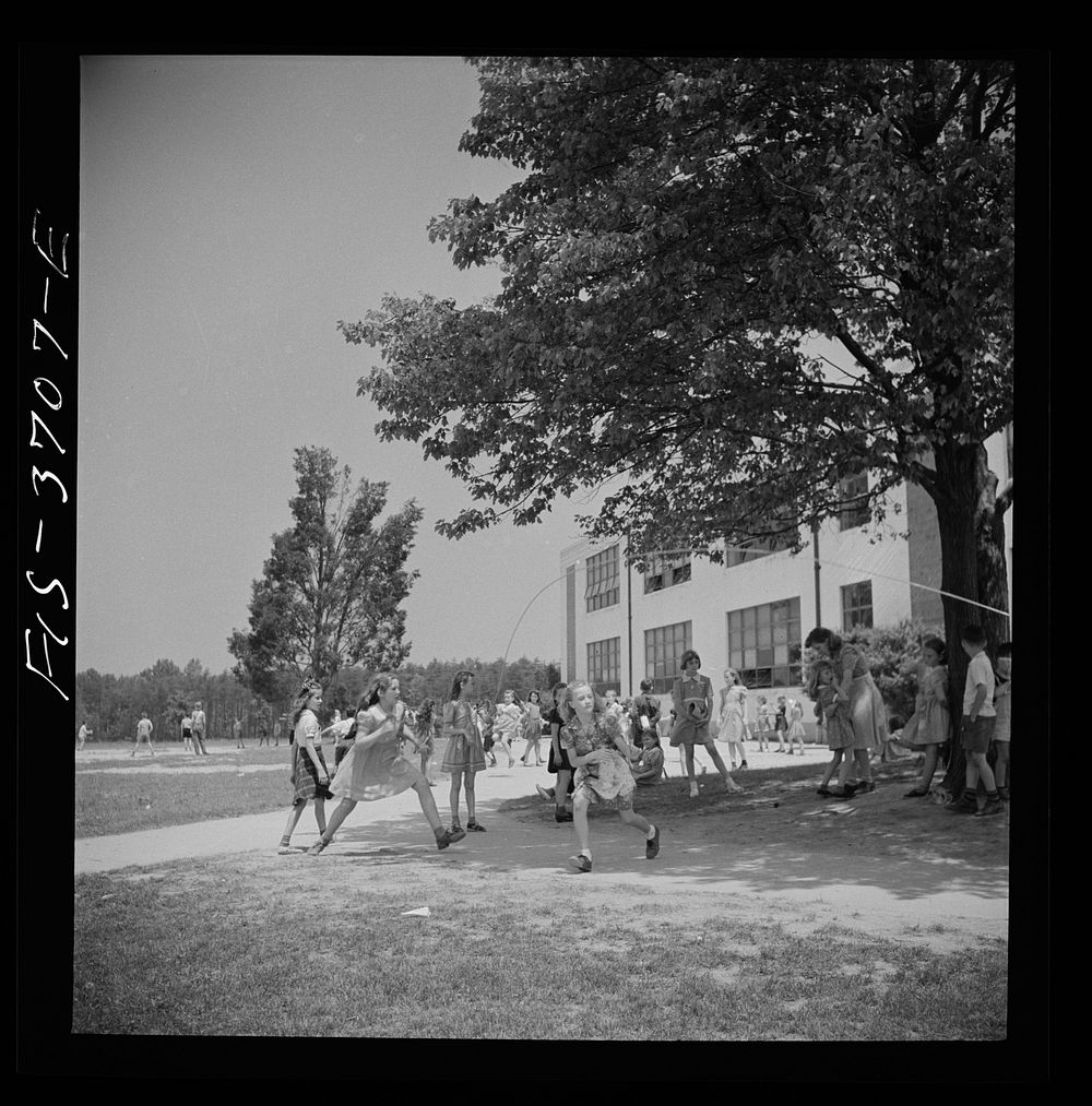 Greenbelt, Maryland. Children playing under trees during a school recreation period. Sourced from the Library of Congress.