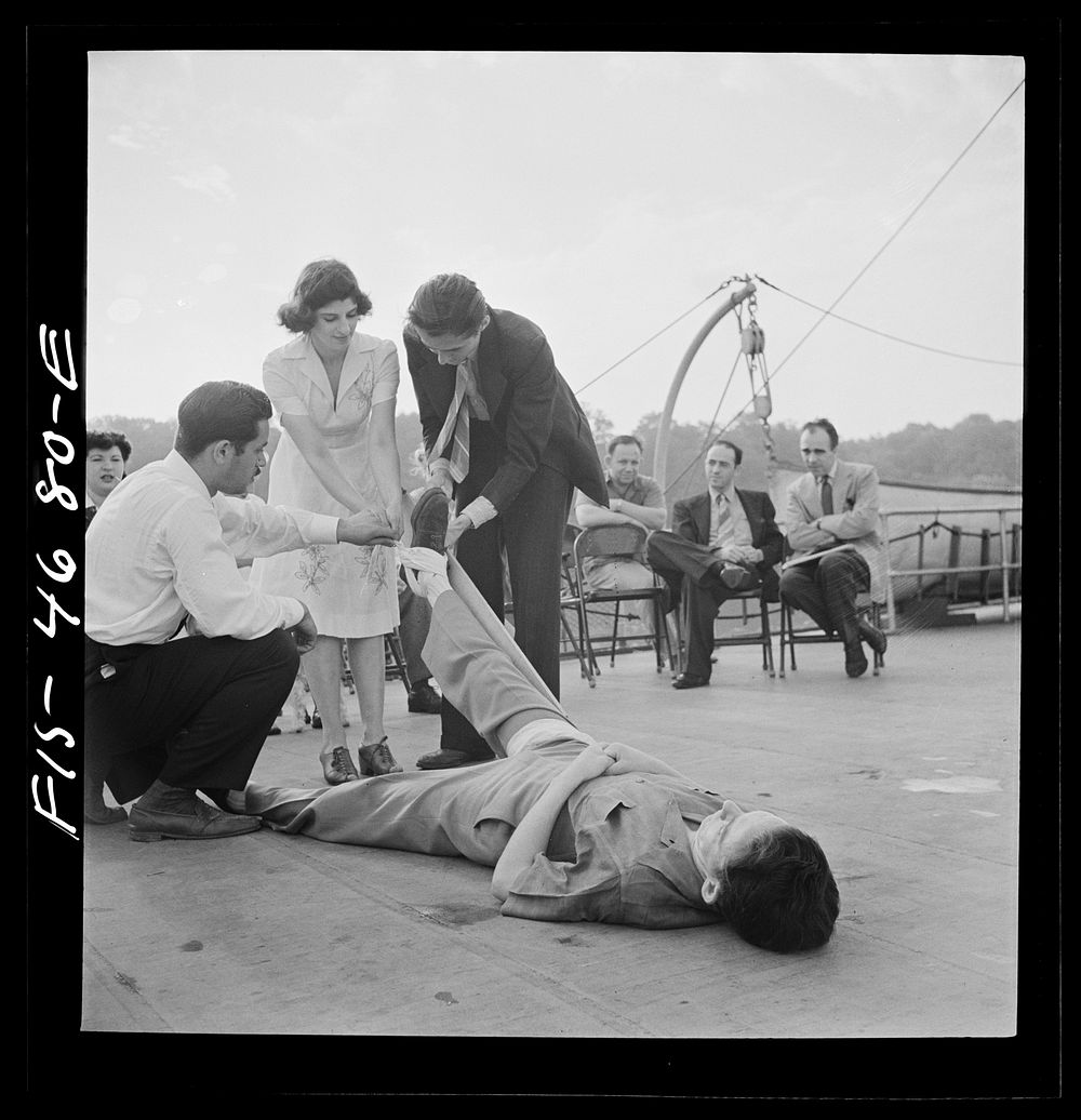 [Untitled photo, possibly related to: Washington, D.C. Applying a splint to a "broken" leg as part of a course in first aid…
