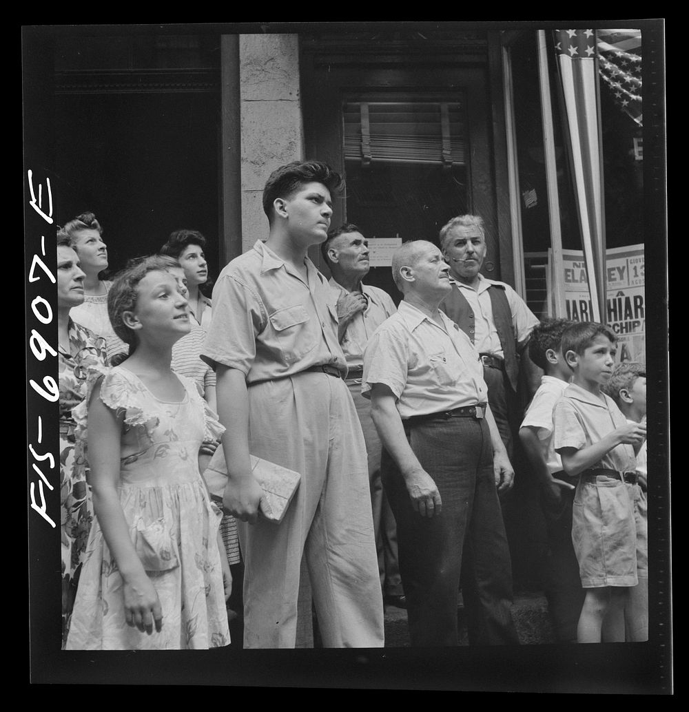 New York, New York. Italian-American in the rain watching a flag raising ceremony in honor of the feast of San Rocco at…