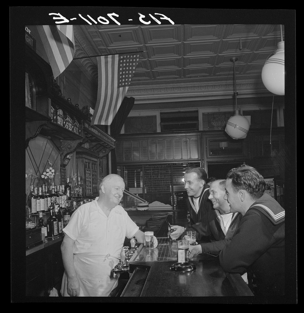 New York, New York. Irish-American bartender serving beer to British sailors in a Third Avenue bar in the "Forties". Sourced…