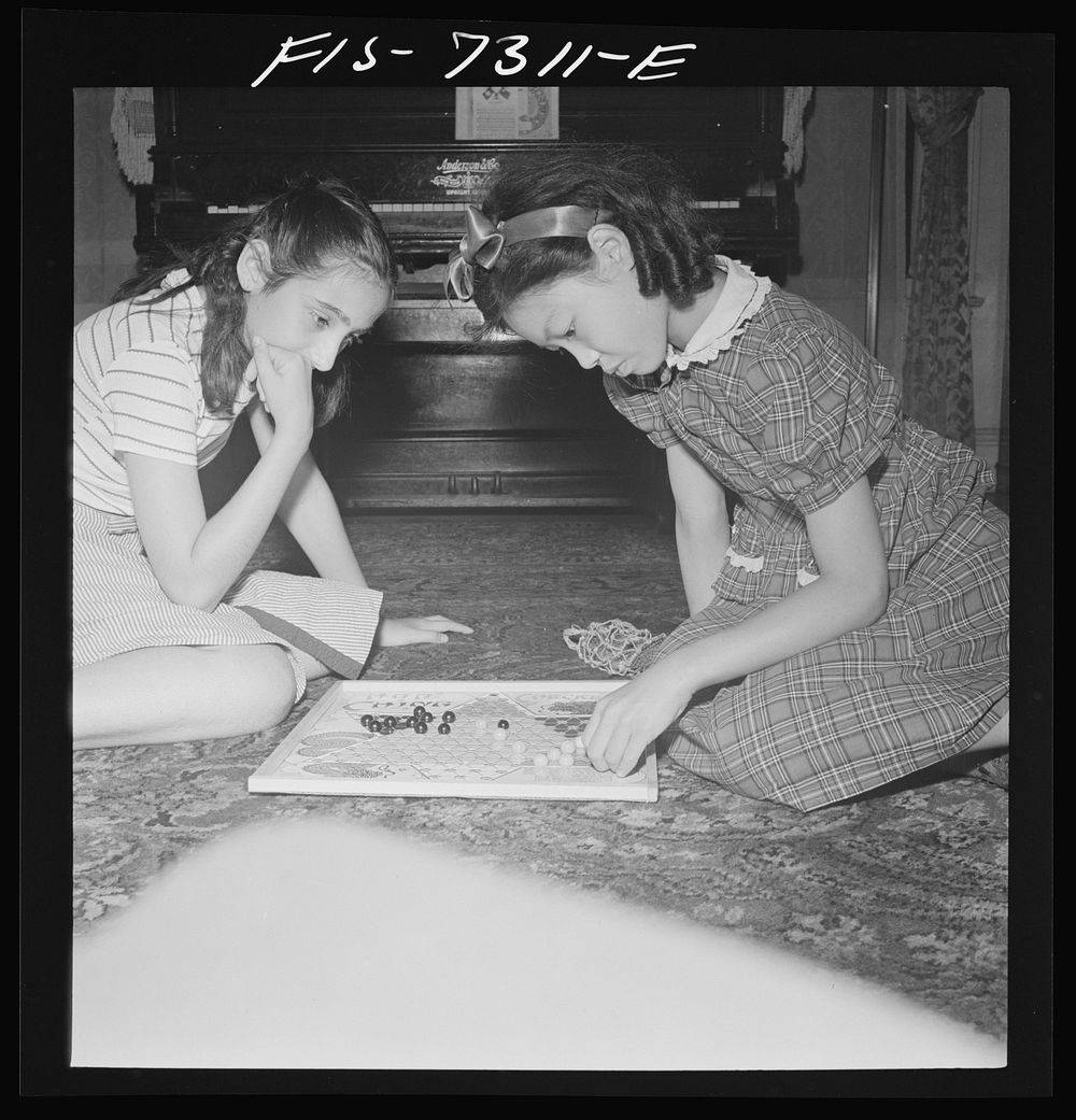 New York, New York. Chinese-American playing Chinese checkers with a Jewish friend in his Flatbush home. Sourced from the…